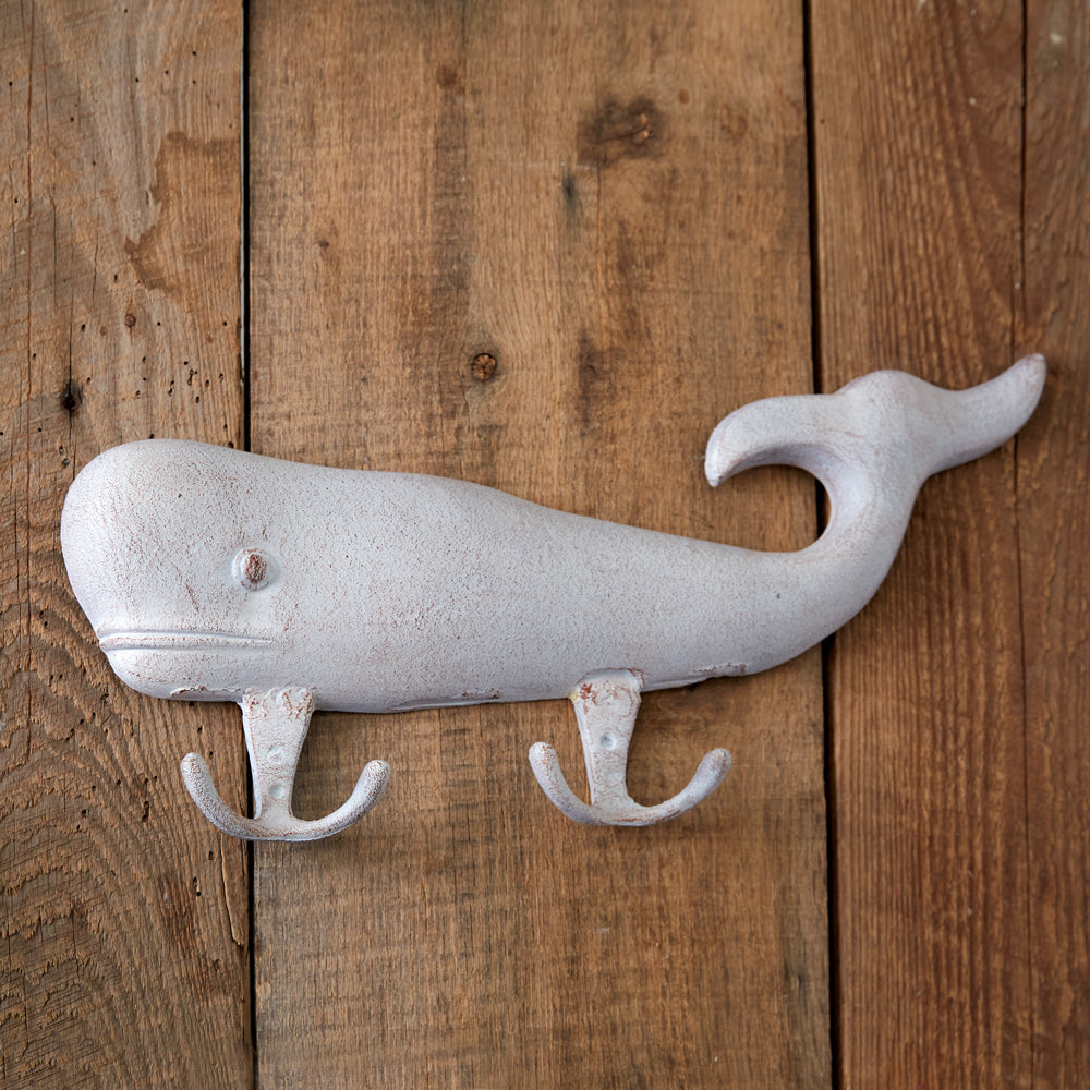 Whitewashed cast iron whale with two hooks, adding nautical charm and functionality to your home decor with seaside elegance.