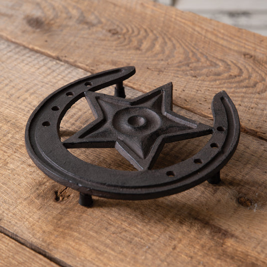 Western-inspired cast iron trivet with cowboy and horse motifs, perfect for protecting kitchen surfaces from hot pans.