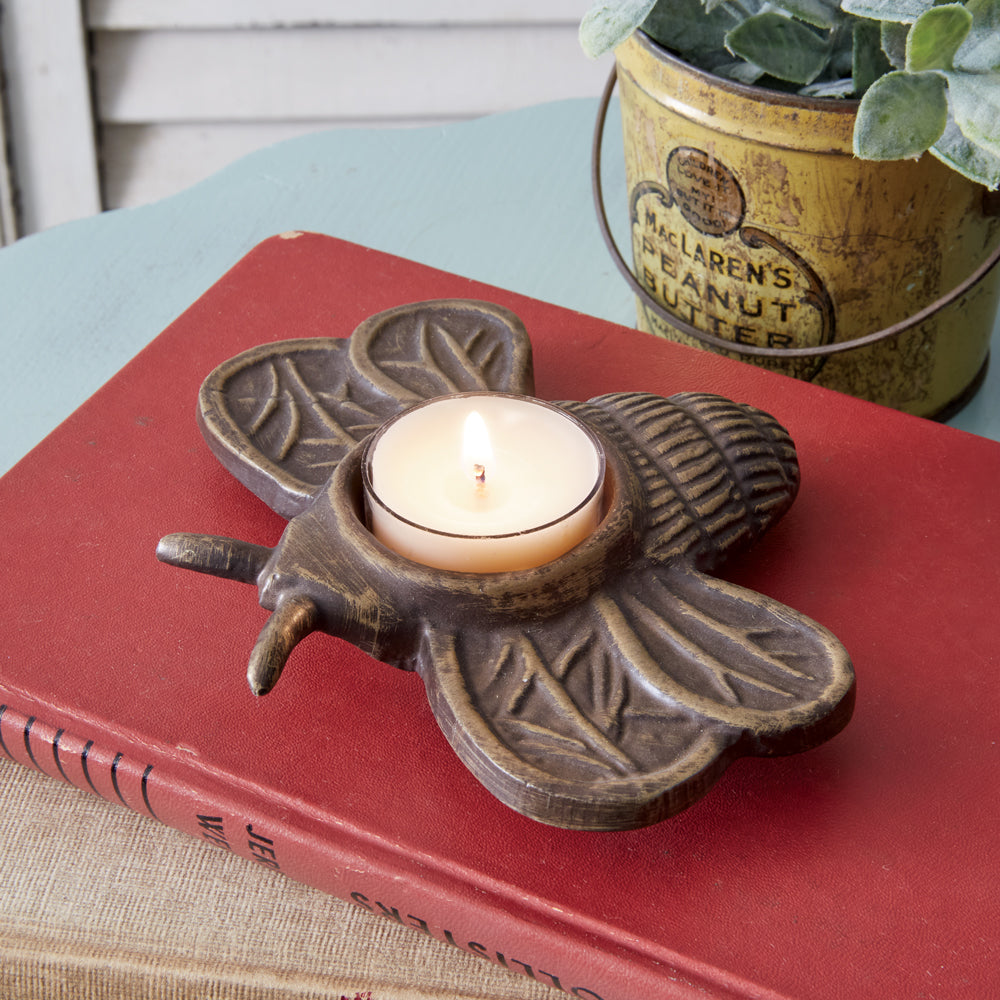 Cast iron bee tealight holder with intricate details, perfect for adding a warm glow to any room. Comes in a set of two.