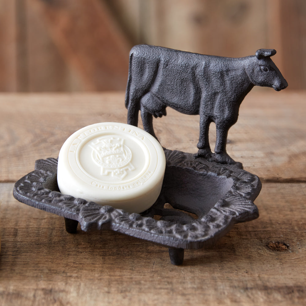 Rustic cast iron soap dish with a detailed cow design on top, featuring drain holes for easy cleaning and a farmhouse charm.