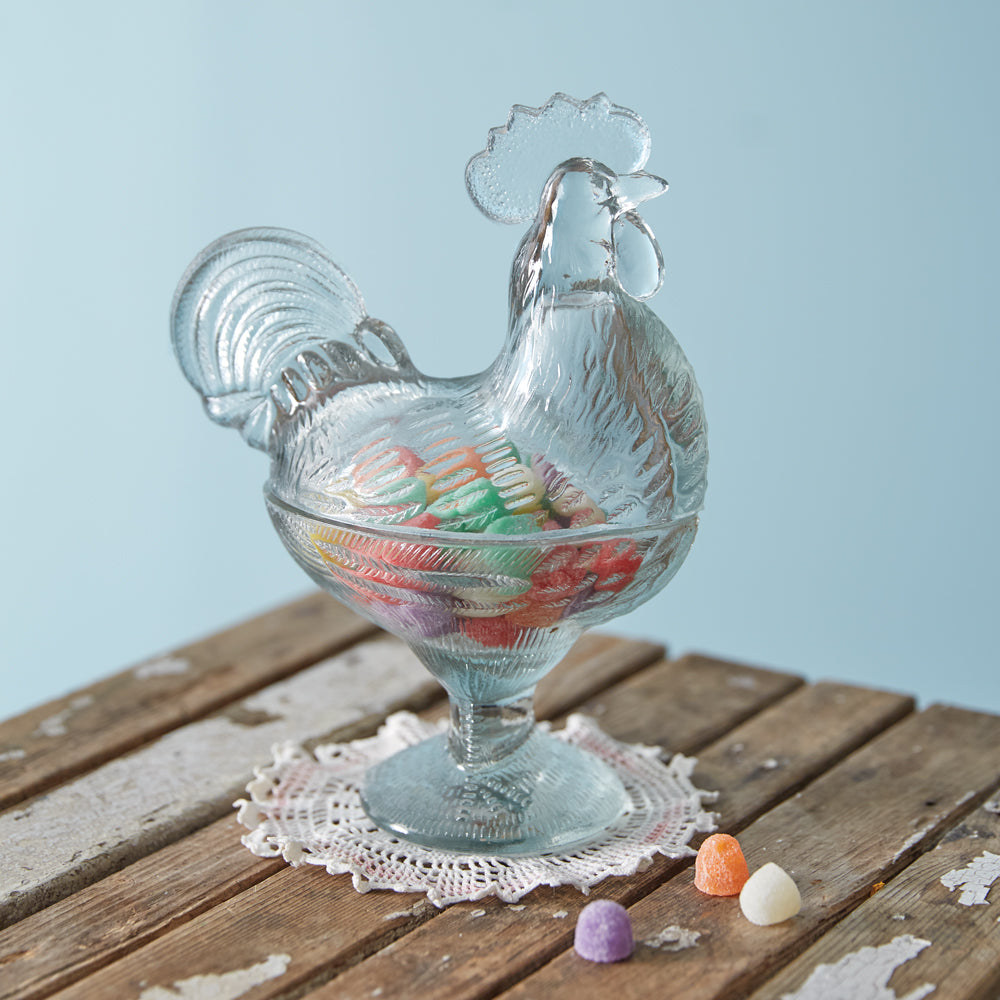 A vintage-inspired glass rooster dish with intricate details, perfect for displaying treats on a spring table or farmhouse decor.