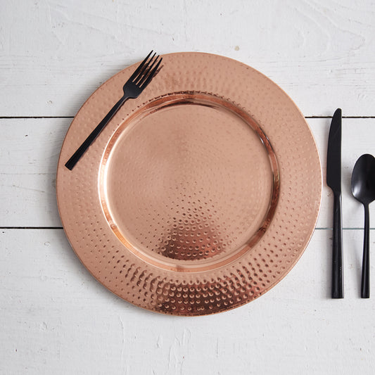 Copper charger with a hand-hammered finish, adding elegance to any table setting; perfect for formal or casual gatherings.