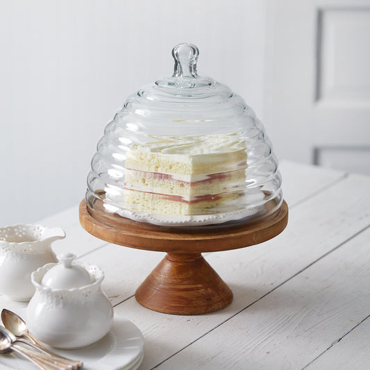 A beautifully crafted Honey Hive Cloche with a mango wood stand, perfect for showcasing desserts at gatherings or tea parties.