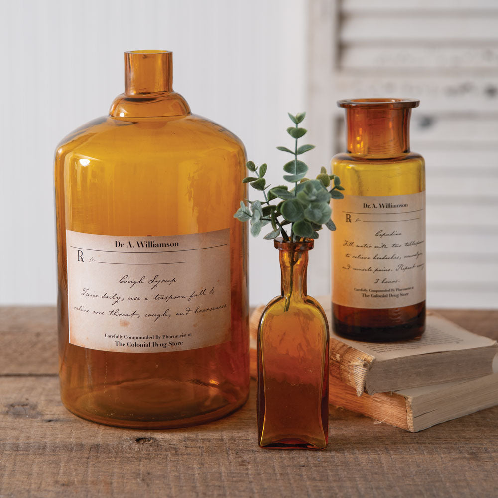 Amber glass apothecary bottle with vintage Capudine label, perfect for decor or displaying a single flower. Timeless elegance.