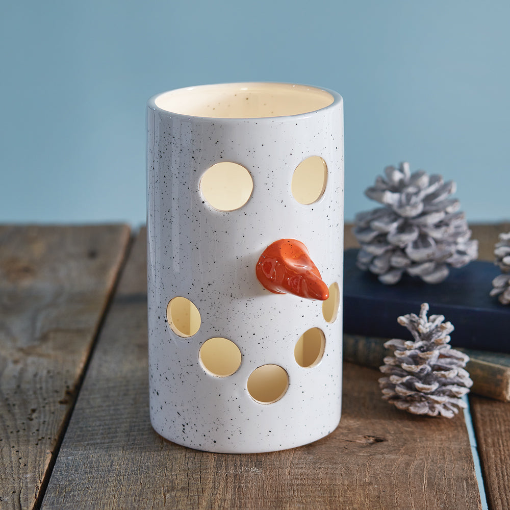 A handcrafted ceramic snowman luminary with a cheerful face, glowing warmly, perfect for festive holiday decor.