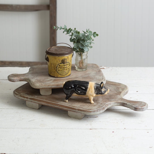 Two multi-toned wooden cutting board risers on a kitchen counter, showcasing rustic farmhouse charm and decorative elegance.