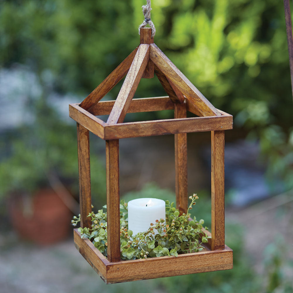 A rustic wood lantern with an open design, featuring a rope handle, perfect for candles or decorative accents.