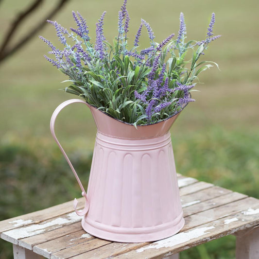 Pink metal milk pitcher with distressed black edges, perfect for adding a rustic charm and vibrant color to any room.