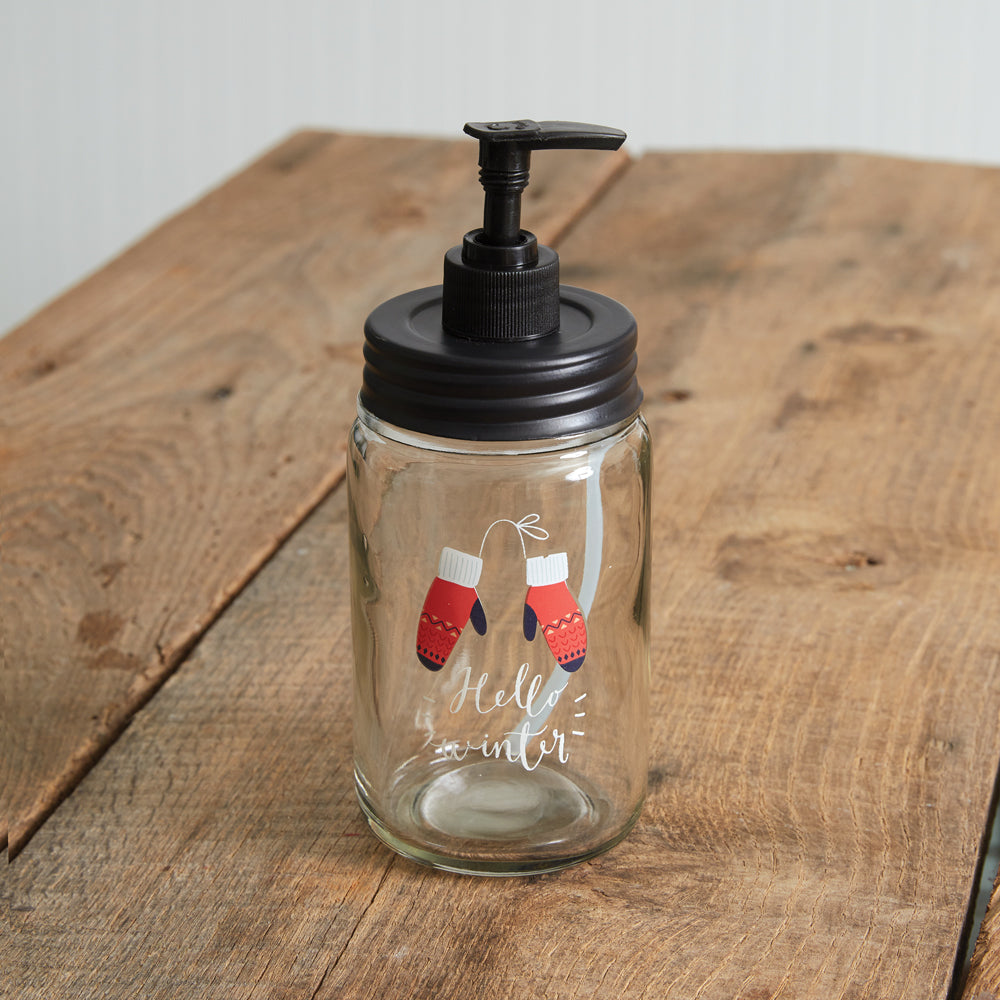 Clear glass soap dispenser with black pump, adorned with red winter mittens, perfect for adding festive charm to your decor.