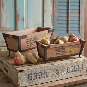 Two vintage-style wooden banana boxes with metal legs, one nested inside the other, showcasing rustic charm and nostalgia.