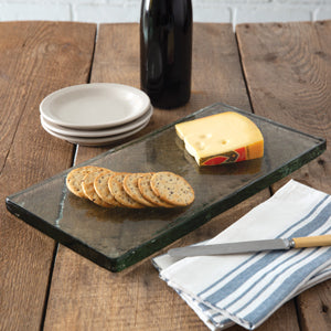 A unique, handmade glass cheese board with a sleek design, featuring protective rubber feet for stability on countertops.