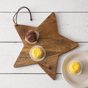 Rustic star-shaped wood board on a festive table, ideal for showcasing holiday treats and decorations with elegant charm.