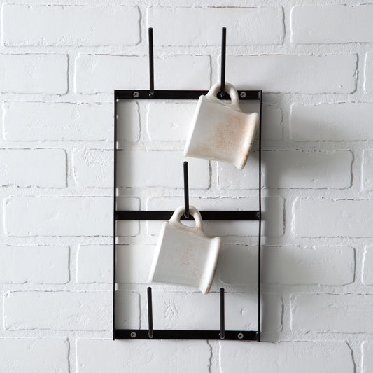 Black metal wall mug rack with five rungs, displaying mugs. Sleek design enhances decor, easy installation with included hardware.