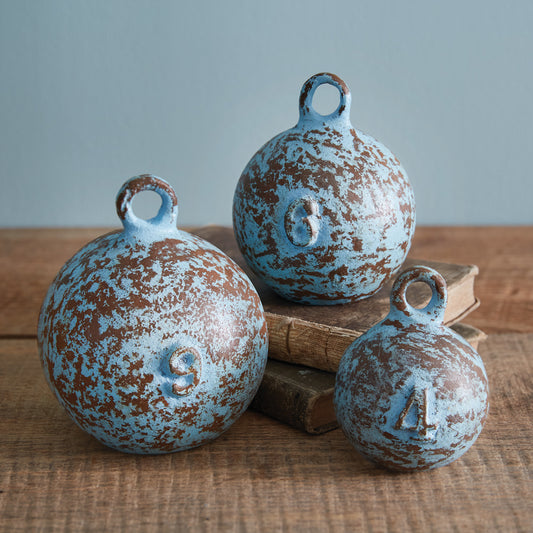 Set of three rustic blue cast iron nautical weights with a weathered finish, perfect for adding a maritime touch to any space.