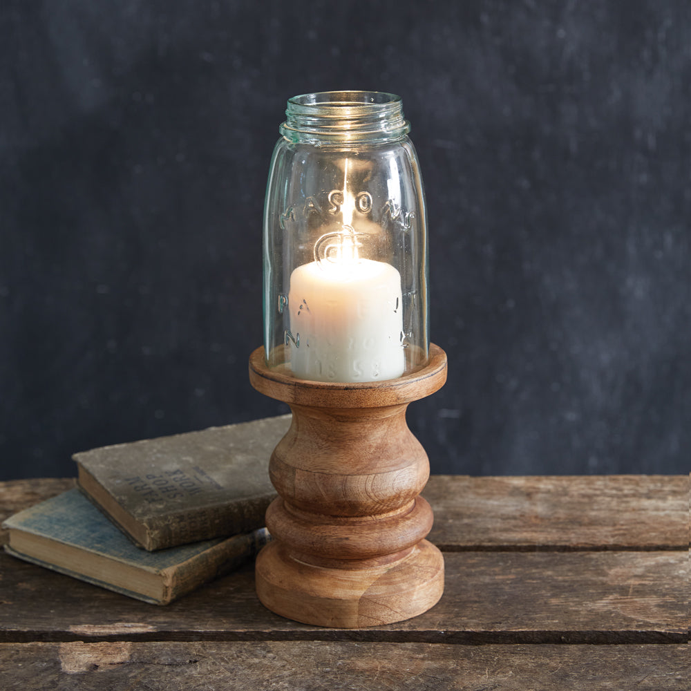 Hand-turned wood candle holder with a mason jar chimney, showcasing rustic elegance and country charm in a cozy setting.