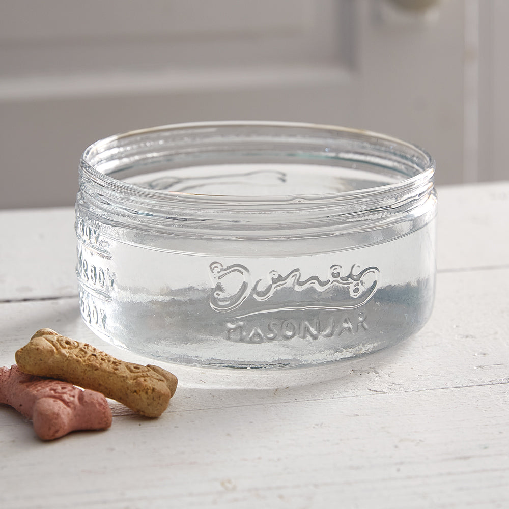 Glass dog bowl with embossed "Bones Mason Jar" lettering, measuring lines, and a dog bone design, adding rustic charm.